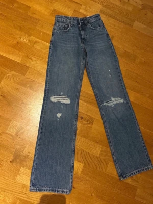  jeans med slitningar Zara - Säljer ett par blå raka jeans från Zara med  slitningar på båda benen. Jeansen är helt oanvända! Skriv för fler frågor💞