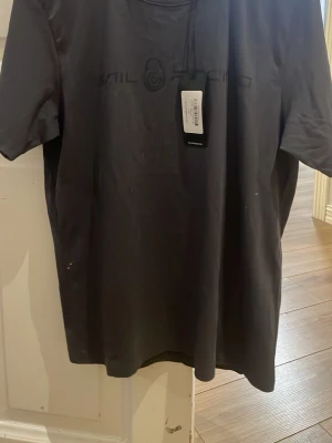 Svart t-shirt från Sail Racing - Snygg svart t-shirt från Sail Racing med diskret logga framtill. Klassisk passform och rund halsringning. Perfekt till jeans eller shorts för en clean look.