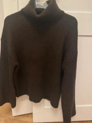 Mörkbrun polotröja stickad - Mysig mörkbrun stickad polotröja med hög krage och långa ärmar. 