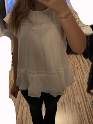 Vit volangblus Gina Tricot  - Söt vit blus med volanger. Blusen har en luftig passform, rund halsringning och korta ärmar. Perfekt att styla med jeans eller kjol för en trendig look. Även perfekt inför våren/sommaren!! Ifrån Gina Tricot (Gina Young) i storlek 170. Nypris vet jag ej tyvvär men säljer för 60 då den är använt 1 gång och är i jätte fint skick!! 