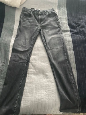 Levi's 512 Slim grå jeans - Säljer ett par snygga grå Levi's 512 Slim jeans med klassisk femficksdesign och dragkedjegylf. Jeansen har en smal passform och är tillverkade i mjukt denimtyg som sitter skönt. Perfekta för dig som gillar en stilren och enkel look. Kan gå ner i pris fö snabb affär
