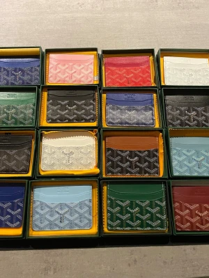  korthållare i flera färger - Exklusiva korthållare  i klassiskt mönstrad canvas och läder. Finns i många färger som blå, rosa, röd, vit, grön, svart, brun och ljusblå. Slimmad design med flera fack för kort. Perfekt accessoar för dig som vill ha något både stilrent och lyxigt. Olika priset för olika färger