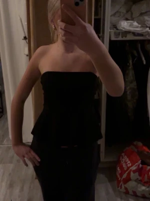 Svart axelbandslös peplum tubtopp!!! - Säljer en svart axelbandslös tubtopp med peplumvolang nedtill super fin!!!!❤️❤️