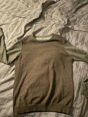 Merinoull tröja från Hansen&Jacob - En merinoull tröja från Hansen&Jacob i tre däva färger. Är i bra skick men har tre hål vid axeln typ som syns på bilden