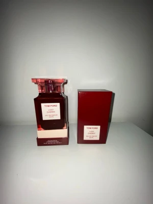 Tom Ford Lost Cherry Eau de Parfum - Tom Ford Lost Cherry Eau de Parfum 100 ml med lyxig, fyrkantig röd glasflaska och matchande röd kartong. Doften är känd för sina söta körsbärstoner och exklusiva känsla. Perfekt för dig som vill sticka ut med en unik och elegant parfym.