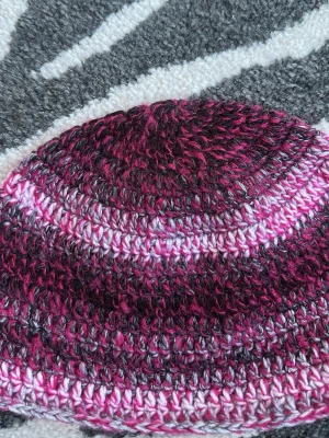 virkad mössa - virkad mössa i coola nyanser av rosa, grått och vitt. Den rosa tråden är fluffig och den andra skiftar mellan svart, grå och vit. Sitter lite löst på mitt huvud med 55cm i omkrets, 17 cm lång.