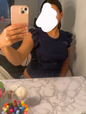 Mörkblå topp med volangärmar - Snygg mörkblå topp med volangdetaljer på axlarna , storlek S men skulle säga att de passar XS då ja har S men den är lite för liten 