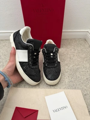 Valentino flycrew - Säljer dessa svarta valentino flycrew i glitter | storlek 37,5 passar 38-38,5 också | väldigt fint skick | bara 3 nitar saknas och lite smuts på ena hälen syns på bild 4 | pris går att diskutera vid snabb och enkel affär | bara skor ingår vid köp | 