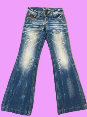 Lowwaist Bootcut jeans med knappar och slitningar - Bootcut jeans med slitningar och vintage stil Midja: 33-34cm Innerben: 79-80cm