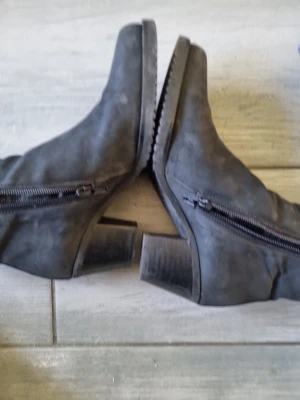 Svarta stövletter med dragkedja - Snygga svarta stövletter med grov klack och dragkedja på sidan. Tillverkade i mockaimitation med räfflad sula för extra grepp. Perfekta för att lyfta din outfit med en cool touch.