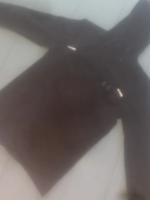 Svart under armour windbreaker  - Säljer en svart winderbreaker från Under Armour bra pris med klassisk logga på bröstet och stor huva med dragsko. Hoodien har långa ärmar och en magficka framtill. Perfekt för dig som gillar sportig och avslappnad stil.