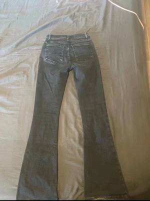 Svarta bootcut jeans med stretch - Snygga svarta bootcut jeans med klassisk femficksdesign och stretchigt material. Jeansen har utsvängda ben och normalhög midja, perfekta för en trendig och avslappnad look.