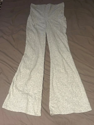 Gråa utsvängda mjukisbyxor - Snygga grå mjukisbyxor med utsvängda ben och hög midja. Byxorna är i mjukt och stretchigt material. 