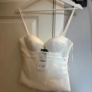 Vit korsettopp från Zara - Säljer en jättefin topp från Zara då den var för liten för mig.