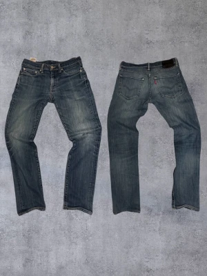 Feta Levi's jeans - Säljer ett par Levi's 511  jeans i blå tvätt med klassiska femficksdetaljer och dragkedja. Jeansen är tillverkade av 98% bomull och 2% elastan för extra stretch och komfort. Perfekt passform och snygga slitningar på benen.