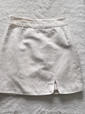 Vit linnekjol - Vit minikjol i linne och med en liten slits framtill.