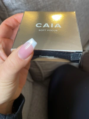 CAIA Soft Focus Translucent puder - Säljer ett CAIA Soft Focus puder i färgen Translucent. Kommer i en snygg, spegelblank fyrkantig förpackning i silver. Perfekt för att fixera sminket och ge en mjuk, matt finish. Enkel att ha med i väskan för touch-ups under dagen.