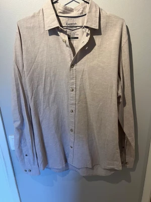 Beige linneskjorta från Jack & Jones - Säljer en stilren beige skjorta från Jack & Jones  i storlek L. Skjortan är tillverkad i linne, har klassisk krage, långa ärmar och knappar framtill. Perfekt för dig som gillar en clean och enkel look.