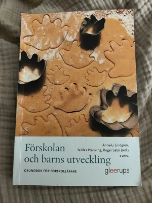Förskolan och barns utveckling - Kursbok för blivande förskollärare, skriven av Anne-Li Lindgren, Niklas Pramling och Roger Säljö. Boken har ett omslag med pepparkaksdeg och formar, och tar upp barns utveckling, lärande och pedagogik i förskolan. Andra upplagan.