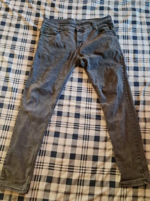 Gråa jeans från Burberry - Snygga grå jeans från Burberry med klassisk femficksmodell och broderad logga på bakfickan. Jeansen har smal passform och är tillverkade i mjukt denimtyg. Perfekta för dig som gillar stilrena och tidlösa plagg.