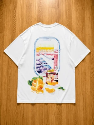 Vit Casa Blanca t-shirt med tryck - Vit t-shirt från Casa Blanca med färgglatt tryck på ryggen som föreställer ett flygplansfönster, apelsiner och ett glas juice. Framsidan har ett mindre tryck med texten 'Casa Airlines' och samma motiv. Klassisk passform och korta ärmar i mjuk bomull.