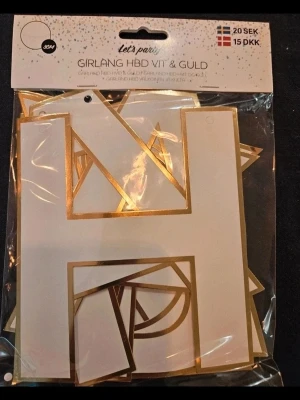 Girlang HBD vit & guld - Säljer en festlig girlang med bokstäver i vitt och guld som bildar 'Happy Birthday'. Perfekt för födelsedagsfirande. Bokstäverna är av papper med guldfolierad kant och levereras i förpackning. Enkel att hänga upp för att skapa en snygg dekoration.