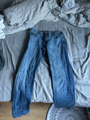 Blå Lee Extreme Motion MVP jeans - Säljer ett par blå Lee Extreme Motion MVP jeans med klassisk femficksmodell och regular fit. Jeansen har en något avsmalnande passform och är tillverkade i stretchigt denim för extra komfort. Perfekta för dig som vill ha både stil och rörelsefrihet.