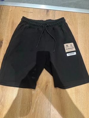 Svarta shorts från Burberry med snörning - Svarta shorts från Burberry med elastisk midja och snörning.