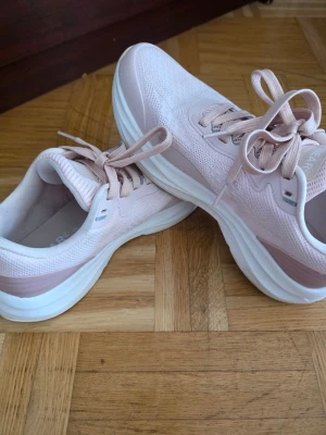 Ljusrosa sneakers med vit sula - Snygga sneakers i ljusrosa med vit tjock sula och matchande ljusrosa skosnören. Ovandelen är i mesh och syntetmaterial för en luftig känsla. Perfekta för dig som gillar en stilren och sportig look.