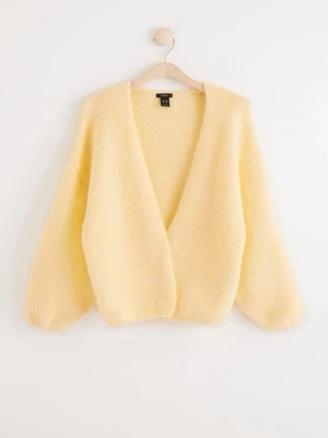 Lindex trendig Gul fluffig kofta  - Mysig ljusgul kofta och ballongärmar. Koftan är fluffig och har en avslappnad passform, perfekt att slänga över en topp. Tillverkad i ett mjukt, stickat material som känns skönt mot huden.