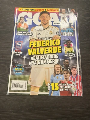 GOAL International fotbollstidning - Säljer ett nummer av GOAL International med Federico Valverde från Real Madrid på omslaget. Tidningen har färgstarkt omslag med flera kända fotbollsspelare och rubriker om fotbollsvärlden. Perfekt för dig som älskar fotboll och vill läsa om de senaste nyheterna och profilerna.