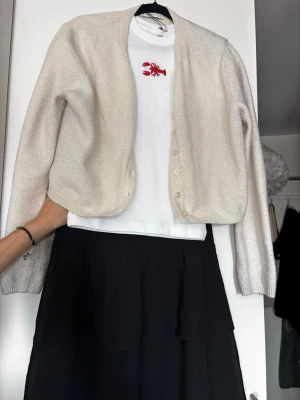 Svart volangkjol med resårmidja - Säljer en svart kortkjol med volanger och bred resår i midjan. Kjolen har en luftig och flowy känsla, perfekt för att styla med en enkel topp eller stickad tröja. Materialet känns lätt och bekvämt. Jättefin kjol men kommer inte till användning hos mig tyvärr!
