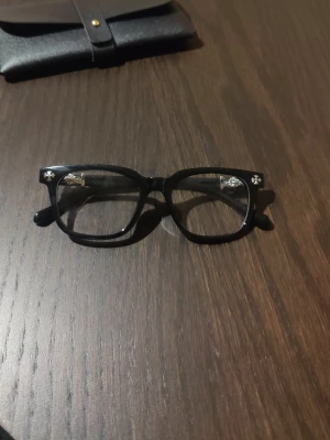 chrome hearts glasögon  - Säljer ett par stilrena glasögon från Chrome Hearts. De kommer med en liten förvaringsväska, perfekt för att skydda glasögonen och komplettera den minimalistiska stilen.  Perfekta för dig som uppskattar en ren och exklusiv look.