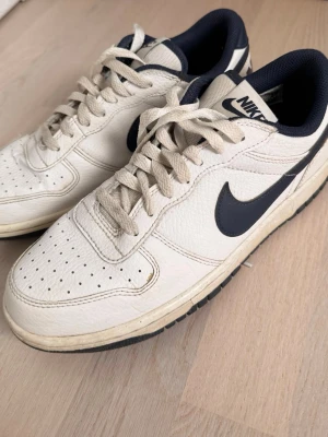 Nike sneakers - Vit / blå. .Lite crease men i övrigt fint skick. Inget slitage under sulorna. Nypris 1149:- https://www.intersport.se/products/nike-big-low-m-sneakers-herr/white-midnight-navy-159497301
