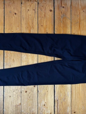 Marinblå träningsleggings från IBODY storlek XS - Snygga marinblå träningsleggings med smal passform och stretchigt material. Perfekta för gymmet, löpning eller yoga. De har en enkel design utan synliga loggor eller detaljer och sitter tajt längs benen. Från IBODY storlek XS