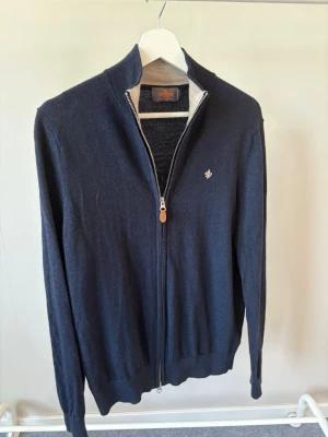 Marinblå ziptröja från Morris - * Märke: Morris Stockholm * Modell: Merino Zip Cardigan * Färg: Navy (mörkblå) * Material: 100 % merinoull * Passform: Slim fit  * Dragkedja: Tvåvägs YKK-dragkedja * Nypris: Cirka 1 900–2 300 kr                                           * Storlek: M, men liten i storleken så kan passa S.
