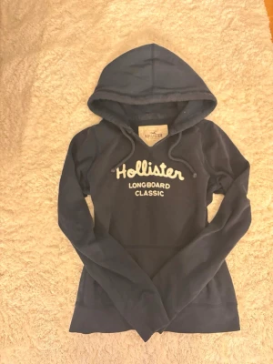 Blå hoodie från Hollister  - Mörkblå hoodie från Hollister med  tryck, storlek M men känns mindre, bra skick, pris kan diskuteras 