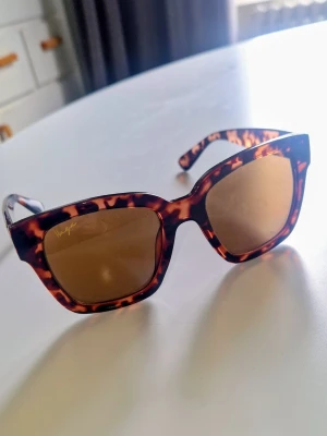 Solglasögon - Snygga solglasögon med cateye båge i brunt leopardmönster och bruna glas. Perfekt accessoar för att lyfta din stil och skydda ögonen mot solen. Tidlös design som passar till många outfits.