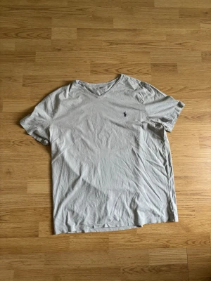 Grå Ralph lauren t shirt i storleken XL - En grå Ralph lauren t shirt i storlek XL. Den är i riktigt fint skick det ända är ett pytte litet hål som du kan se på sista bilden. Pris går att diskuteras vid snabb affär!