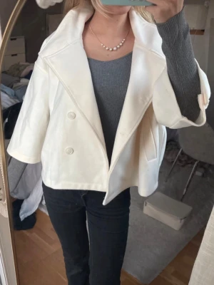  Trekvartsärmad kappa - En vit kappa M trekvartsärmar från Gina Tricot i storlek M men passar på mig som brukar bära S/XS.
