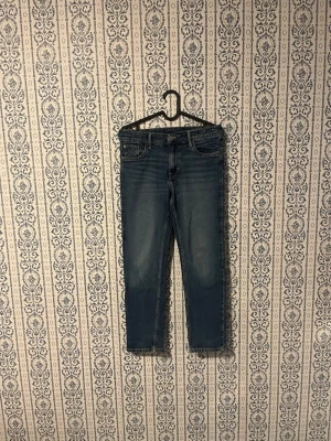 Blå raka jeans i storlek 152 - Säljer ett par klassiska blå jeans med raka ben och fem fickor. Jeansen har en snygg tvättad look och normal midja. Passar dig som gillar en enkel och tidlös stil. Perfekta till vardagsoutfiten och lätta att matcha med det mesta.