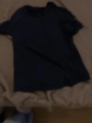 Mörkblå basic t-shirt - En enkel och stilren mörkblå t-shirt i klassisk modell. T-shirten har korta ärmar och rund halsringning, perfekt till jeans eller shorts. Materialet ser ut att vara mjukt och bekvämt, troligen bomull.