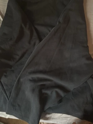 Svart tröja i mjukt tyg - En svart tröja med omlott-design i ett mjukt och följsamt material. Tröjan har en enkel och stilren look som passar till många olika outfits. Perfekt för dig som gillar en klassisk och tidlös stil.