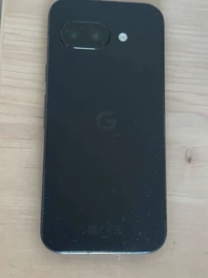 Svart Google Pixel Android-telefon - Säljer en svart Google Pixel med stilren design och glasbaksida. Telefonen har en enkel kamera och LED-blixt på baksidan samt en stor skärm på framsidan. Perfekt för dig som gillar Android och vill ha en smidig mobil.