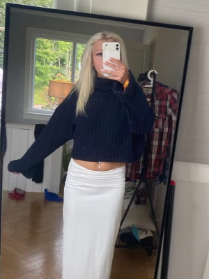 Mörkblå polotröja  - Säljer en stilren vit långkjol med rak passform. Kjolen har en enkel och clean look, perfekt att matcha med olika toppar. Materialet ser mjukt och följsamt ut, vilket ger en snygg siluett.