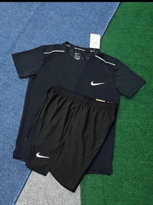 Svart träningsset från Nike - Säljer ett svart träningsset från Nike med t-shirt och shorts. T-shirten har vita detaljer på axlarna och Nike-logga på bröstet. Shortsen har resår i midjan och vit Nike-logga på benet. Perfekt för gymmet eller löpning.