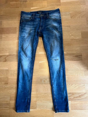 Jeans  - Säljer dessa super feta jeans i från Jack and Jones 29:30 st sitter magiskt på och har ett par riktigt unika slitningar som sticker ut från mängden dessa är väldigt sällsynta att få tag på 