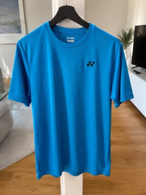 Blå sport t-shirt från Yonex - blå sport t-shirt från Yonex med rund hals och korta ärmar. perfekt för träning eller varmt väder. 