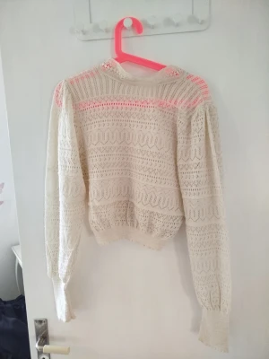 Vit spetsstickad tröja från Zara - Supersöt vit spetströja tröja från Zara med puffärmar. Tröjan har ett genombrutet mönster och ribbade muddar vid ärmslut och midja.