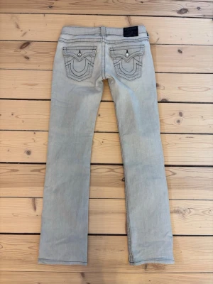 Ljusgrå true religion jeans  - Ljusgrå true religion jeans med diamant knappar som söker nytt hem. Säljer de absolut finaste jeansen jag sett men de är tyvvär för små för mig❤️